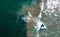 Person gracefully surfs the waves on a surfboard from a breathtaking aerial perspective