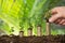 Person Hand Holding Small Plant On Stacked Coins