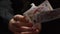 Person hand holds deck of flying cards on black background