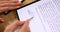 Person hand holds stylus and puts an electronic signature in contract on tablet