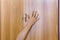 Person hand protruding from wardrobe door.