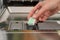 Person Hands Putting Dishwasher Tablet In Dishwasher Box