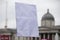 A person holding a blank protest banner at a political rally