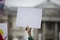 A person holding a blank protest banner at a political rally