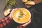 Person holding bowl of warm pumpkin soup in hands