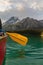 Person holding canoe paddle on pristine alpine lake