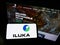 Person holding cellphone with logo of Australian mining company Iluka Resources Limited on screen in front of webpage.