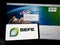 Person holding cellphone with logo of company SEFE Securing Energy for Europe GmbH on screen in front of business webpage.