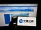Person holding cellphone with logo of power company China Three Gorges Corporation (CTG) on screen in front of webpage.