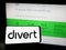 Person holding cellphone with logo of US food technology company Divert Inc. on screen in front of business webpage.