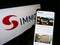 Person holding cellphone with webpage of Austrian real estate investment company S IMMO AG on screen with logo.