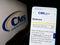 Person holding cellphone with webpage of Centers for Medicare and Medicaid Services (CMS) on screen with logo.