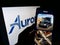 Person holding cellphone with webpage of self-driving vehicle company Aurora Innovation Inc. on screen with logo.