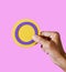 Person holding a circular intersex flag in their hand