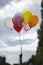 Person holding colored helium balloons