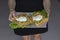 Person holding a dish of Waffles with pouched eggs, avocado and lettuce