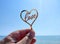 Person holding fingers hand stick shape heart word Love you background sea waves
