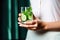 a person holding a glass of water infused with cucumber and mint