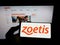 Person holding mobile phone with logo of American animal drug company Zoetis Inc. on screen in front of business web page.