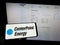 Person holding mobile phone with logo of American utility company CenterPoint Energy Inc. on screen in front of web page.