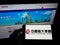 Person holding mobile phone with logo of Chinese property company Evergrande Real Estate Group on screen in front of webpage.