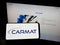 Person holding mobile phone with logo of French medical technology company Carmat SA on screen in front of web page.