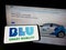 Person holding mobile phone with logo of Indian ride-sharing company BluSmart Mobility on screen in front of web page.