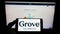 Person holding mobile phone with logo of US consumer goods company Grove Collaborative Inc. on screen in front of web page.