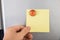 Person holding note sticked on fridge door