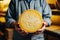 A person holding a piece of cheese in their hands. Homemade cheese production on a farm. Natural product. Close-up. Farming
