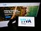 Person holding smartphone with logo of Australian oil refining company Viva Energy Group Ltd on screen in front of website.