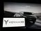 Person holding smartphone with logo of Chinese luxury car manufacturer Voyah on screen in front of website.