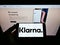 Person holding smartphone with logo of Swedish payment company Klarna Bank AB on screen in front of website.