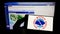 Person holding smartphone with logo of US agency National Weather Service (NWS) on screen in front of website.
