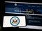 Person holding smartphone with seal of United States Department of State (DOS) on screen in front of website.