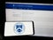 Person holding smartphone with seal of United States Department of the Treasury (USDT) on screen in front of website.
