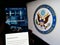 Person holding smartphone with webpage of United States Department of State (DOS) on screen in front of logo.