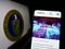 Person holding smartphone with website of United States Department of Energy (DOE) on screen in front of seal.