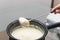 Person holding a spoon with porridge over the black cooker