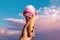 a person holding up a pink ice cream cone in the sunny sky, in the style of lush colors, eye-catching composition