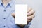 Person holding a white business card on a white background, vertical, template, blue shirt