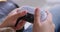 Person holds controller for video game console and presses buttons.