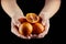 Person holging handful of half and whole red or blood oranges on black background