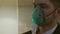 A person inhales through an inhaler mask
