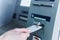 Person insert card to automated teller machine. Cashing non-cash money by individual