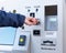 Person inserts card into vending machine to buy ticket at self service machine