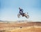 Person, jump and dirt bike of professional motorcyclist in the air for trick, stunt or race on outdoor track. Expert