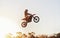 Person, jump and motorcyclist in the air with sunset on mockup for trick, stunt or ramp on outdoor dirt track. Expert