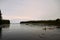 Person kayaking in a tranquil bay at sunrise