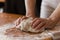 A person kneading the whole pizza dough